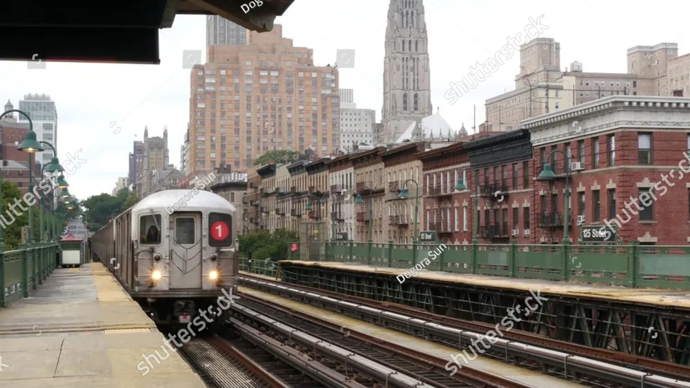 A subway train pulling into an elevated city platform