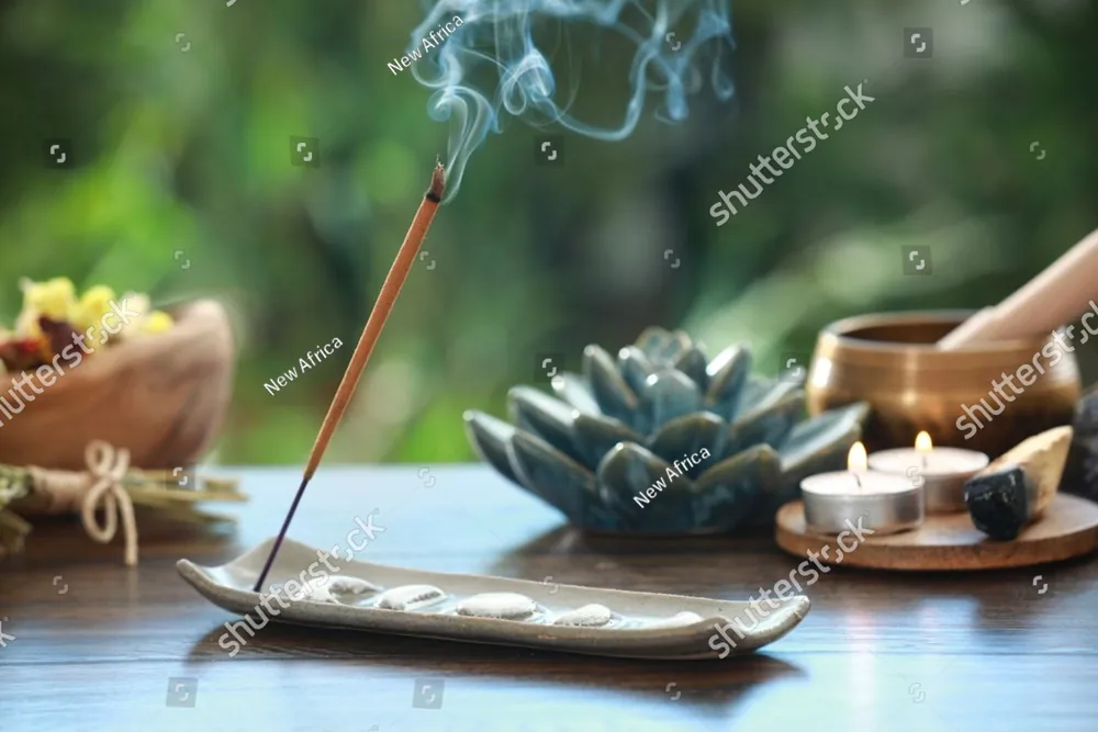 Incense, candles and a singing bowl on a table