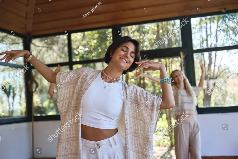 A woman dancing freely on a sunny porch